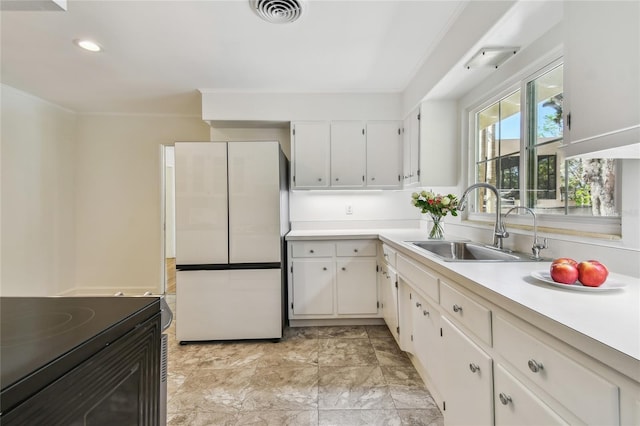 3001 Bay Shore Cir, Sarasota, FL 34234 - kitchen with freestanding refrigerator, a sink, light countertops, black electric range oven, and white cabinets
