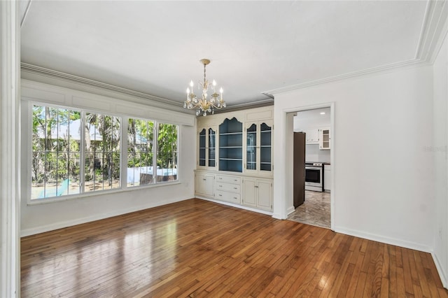 3001 Bay Shore Cir, Sarasota, FL 34234 - unfurnished room featuring a chandelier, ornamental molding, hardwood / wood-style flooring, and baseboards