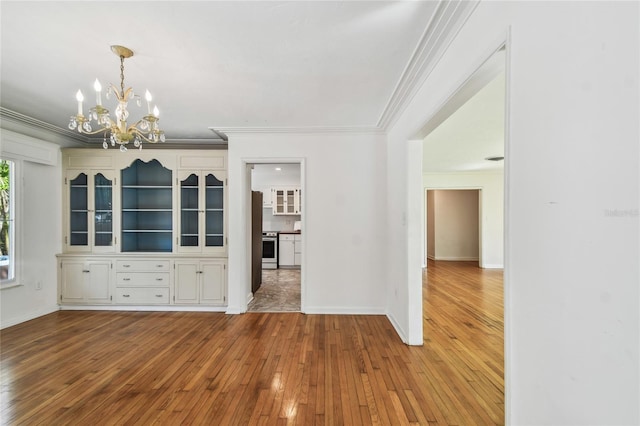 3001 Bay Shore Cir, Sarasota, FL 34234 - unfurnished dining area with crown molding, wood-type flooring, a chandelier, and baseboards