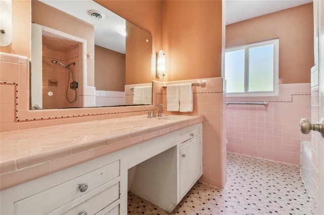 3001 Bay Shore Cir, Sarasota, FL 34234 - bathroom with tile walls, a tile shower, a wainscoted wall, and vanity