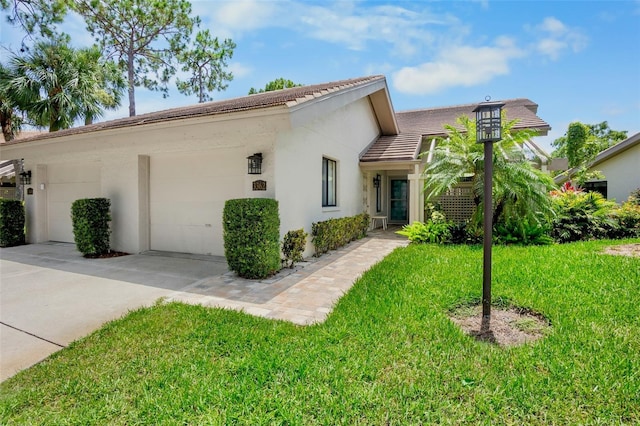 3362 Sandleheath Unit 12, Sarasota, FL 34235 - view of front of home featuring a garage, a front yard, stucco siding, and concrete driveway