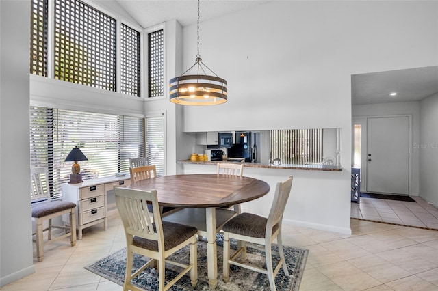 3362 Sandleheath Unit 12, Sarasota, FL 34235 - dining room featuring light tile patterned floors, a towering ceiling, baseboards, and a chandelier