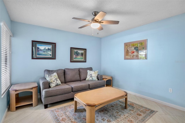 3362 Sandleheath Unit 12, Sarasota, FL 34235 - living area with a ceiling fan, baseboards, a textured ceiling, and light tile patterned floors