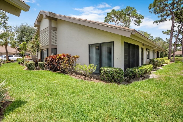 3362 Sandleheath Unit 12, Sarasota, FL 34235 - view of property exterior with stucco siding and a yard
