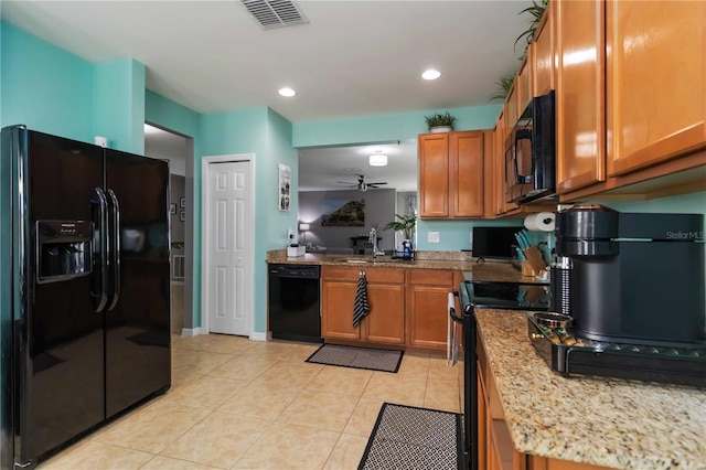 8937 Excelsior Loop, Venice, FL 34293 - kitchen with black appliances, brown cabinetry, a sink, light tile patterned flooring, and recessed lighting