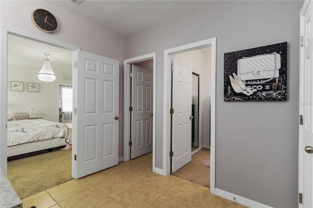8937 Excelsior Loop, Venice, FL 34293 - bedroom with light carpet, light tile patterned floors, baseboards, and a chandelier