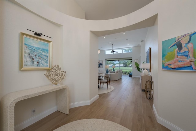 7952 Hampton Ct, University Park, FL 34201 - corridor with light wood-style flooring, a high ceiling, baseboards, and recessed lighting