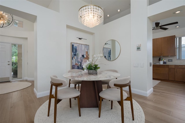 7952 Hampton Ct, University Park, FL 34201 - dining area featuring a chandelier, light wood-style floors, a high ceiling, baseboards, and ceiling fan