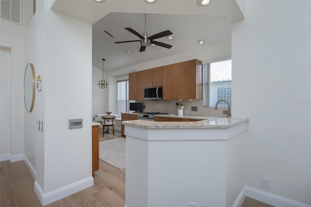 7952 Hampton Ct, University Park, FL 34201 - kitchen featuring stainless steel appliances, brown cabinetry, light wood-style floors, ceiling fan, and baseboards