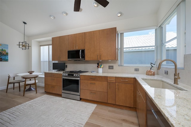 7952 Hampton Ct, University Park, FL 34201 - kitchen with appliances with stainless steel finishes, a sink, brown cabinets, and lofted ceiling