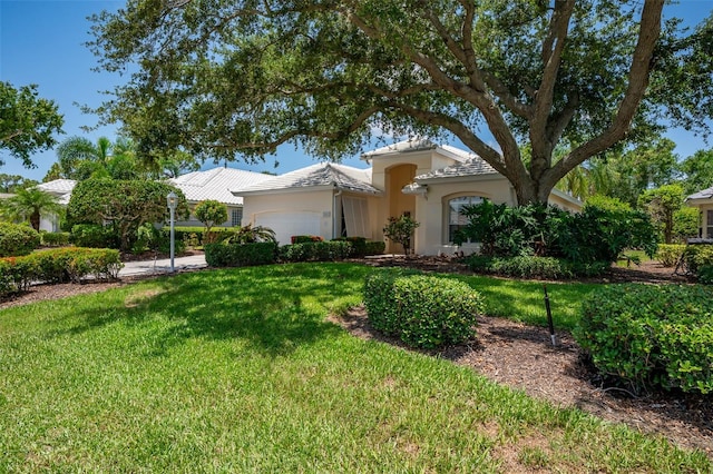 7952 Hampton Ct, University Park, FL 34201 - mediterranean / spanish house with an attached garage, a front yard, and stucco siding