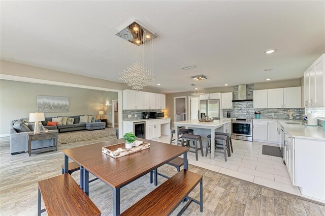 3903 Bayside Dr, Bradenton, FL 34210 - dining room featuring a chandelier, wine cooler, recessed lighting, and light wood-style floors