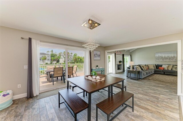 3903 Bayside Dr, Bradenton, FL 34210 - dining area with a chandelier, light wood-type flooring, and baseboards