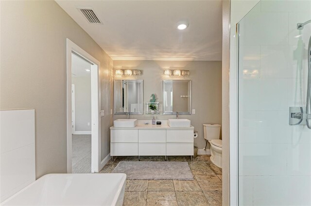 3903 Bayside Dr, Bradenton, FL 34210 - bathroom with double vanity, toilet, baseboards, and a stall shower