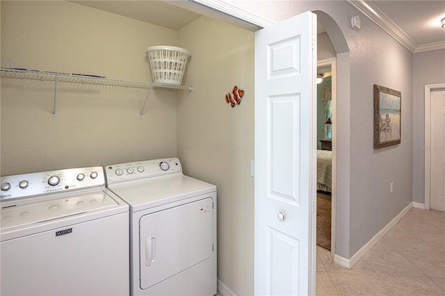 7005 River Hammock Dr Unit 303, Bradenton, FL 34212 - washroom with washer and dryer, arched walkways, ornamental molding, light tile patterned floors, and baseboards