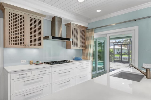 510 Wedge Ln, Longboat Key, FL 34228 - kitchen with wall chimney range hood, stainless steel gas cooktop, a sink, light countertops, and crown molding