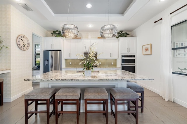 826 Honeyflower Loop, Bradenton, FL 34212 - kitchen featuring stainless steel appliances, backsplash, a center island with sink, white cabinets, and recessed lighting