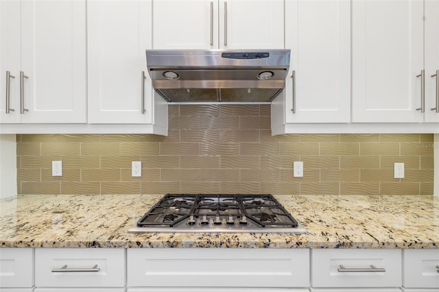 826 Honeyflower Loop, Bradenton, FL 34212 - kitchen with extractor fan, stainless steel gas cooktop, backsplash, white cabinetry, and light stone countertops
