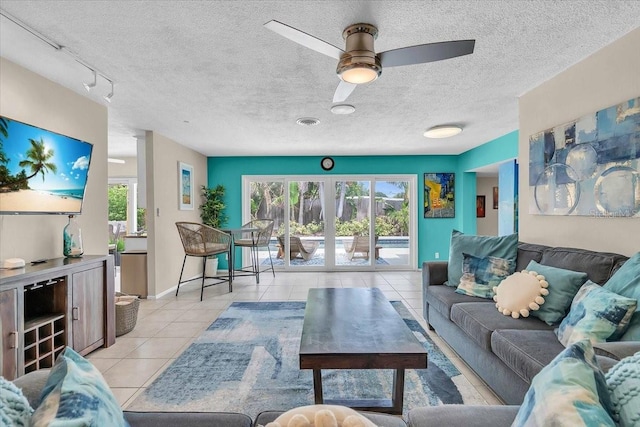6731 Washington Pl, Bradenton, FL 34207 - living area featuring light tile patterned floors, plenty of natural light, a textured ceiling, ceiling fan, and baseboards