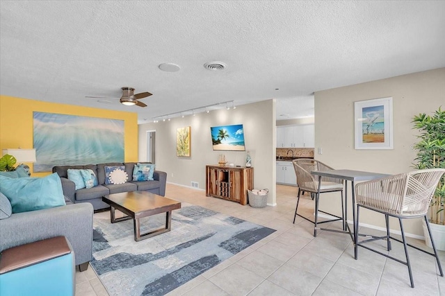 6731 Washington Pl, Bradenton, FL 34207 - living room with track lighting, light tile patterned flooring, a textured ceiling, ceiling fan, and baseboards