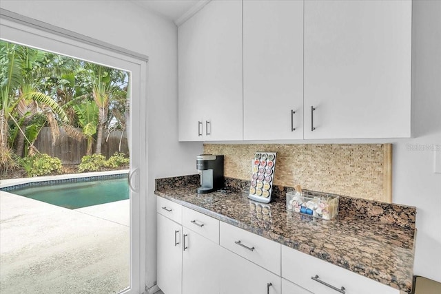 6731 Washington Pl, Bradenton, FL 34207 - kitchen featuring tasteful backsplash, dark stone counters, and white cabinets