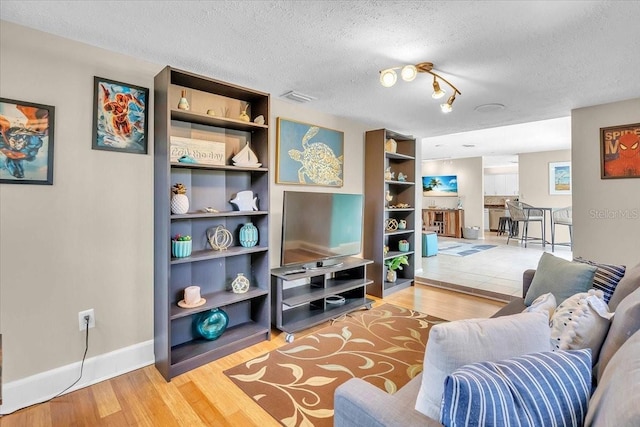 6731 Washington Pl, Bradenton, FL 34207 - living room with wood finished floors, a textured ceiling, and baseboards