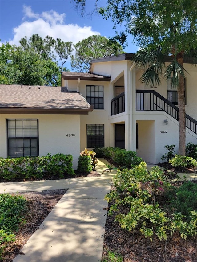 4835 Winslow Beacon Unit 46, Sarasota, FL 34235 - view of front of house featuring stucco siding, a balcony, and roof with shingles
