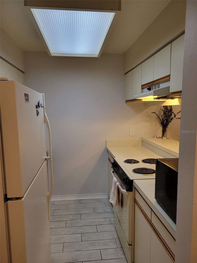 4835 Winslow Beacon Unit 46, Sarasota, FL 34235 - kitchen featuring white appliances, under cabinet range hood, white cabinets, light countertops, and wood tiled floors