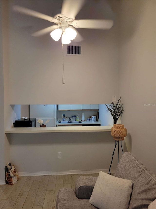 4835 Winslow Beacon Unit 46, Sarasota, FL 34235 - kitchen featuring freestanding refrigerator, wood finished floors, a ceiling fan, baseboards, and a sink