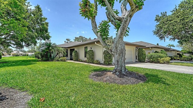 3734 Ballantrae Dr Unit 19D, Sarasota, FL 34238 - view of front of home with an attached garage, stucco siding, a front lawn, and concrete driveway