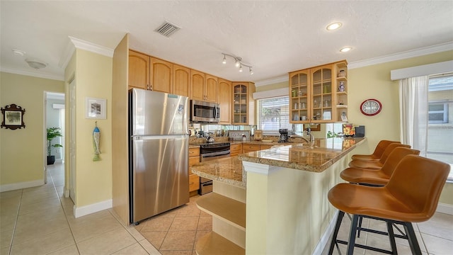 1116 S Moonmist Ct Unit M12, Sarasota, FL 34242 - kitchen with stainless steel appliances, open shelves, a peninsula, ornamental molding, and a kitchen breakfast bar