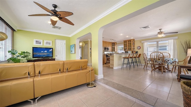 1116 S Moonmist Ct Unit M12, Sarasota, FL 34242 - living area with a ceiling fan, crown molding, arched walkways, light tile patterned flooring, and recessed lighting