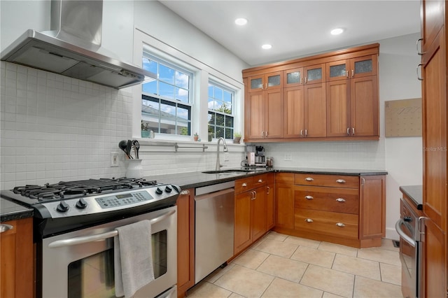 480 28th Ave N, Saint Petersburg, FL 33704 - kitchen featuring appliances with stainless steel finishes, wall chimney range hood, a sink, brown cabinetry, and decorative backsplash