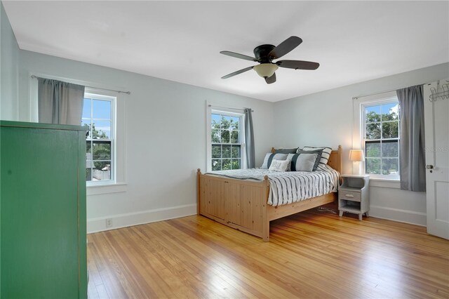 480 28th Ave N, Saint Petersburg, FL 33704 - bedroom featuring multiple windows, light wood-style flooring, baseboards, and a ceiling fan
