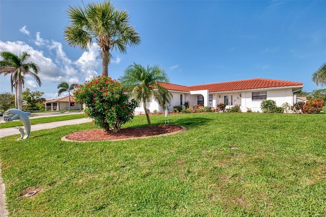 74 Windsor Dr, Englewood, FL 34223 - view of front of home with a tiled roof, stucco siding, concrete driveway, and a front yard