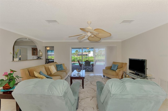 74 Windsor Dr, Englewood, FL 34223 - living room featuring ceiling fan, crown molding, a textured ceiling, arched walkways, and light tile patterned floors