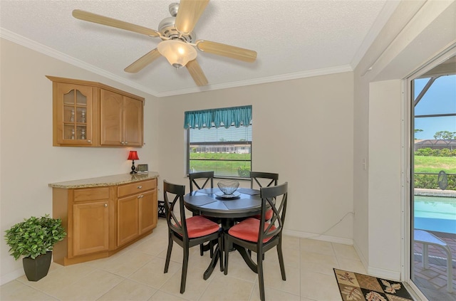 74 Windsor Dr, Englewood, FL 34223 - dining space with plenty of natural light, ornamental molding, a textured ceiling, a ceiling fan, and light tile patterned floors