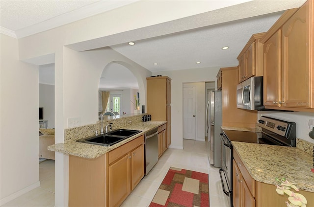 74 Windsor Dr, Englewood, FL 34223 - kitchen with appliances with stainless steel finishes, arched walkways, light stone countertops, light tile patterned flooring, and a textured ceiling