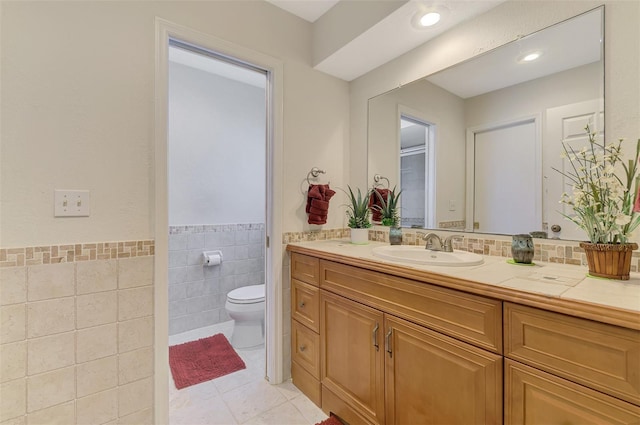 74 Windsor Dr, Englewood, FL 34223 - full bathroom featuring vanity, tile walls, tile patterned flooring, and a wainscoted wall
