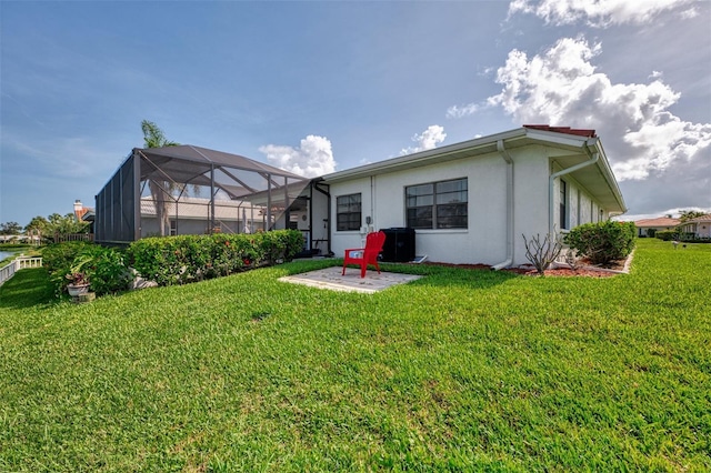 74 Windsor Dr, Englewood, FL 34223 - rear view of house featuring stucco siding, a lawn, and glass enclosure