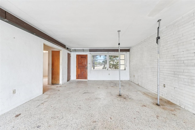 9300 Gulf Blvd, St Pete Beach, FL 33706 - unfurnished living room featuring brick wall and a garage