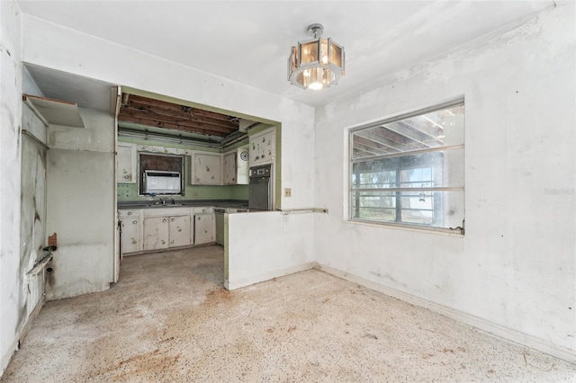 9300 Gulf Blvd, St Pete Beach, FL 33706 - kitchen with oven, baseboards, dark countertops, a peninsula, and dark aggregate flooring