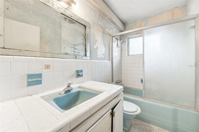 9300 Gulf Blvd, St Pete Beach, FL 33706 - full bath with vanity, toilet, bath / shower combo with glass door, tile walls, and speckle patterned floor