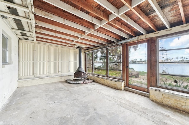 9300 Gulf Blvd, St Pete Beach, FL 33706 - unfurnished sunroom featuring a water view, a wood stove, and plenty of natural light