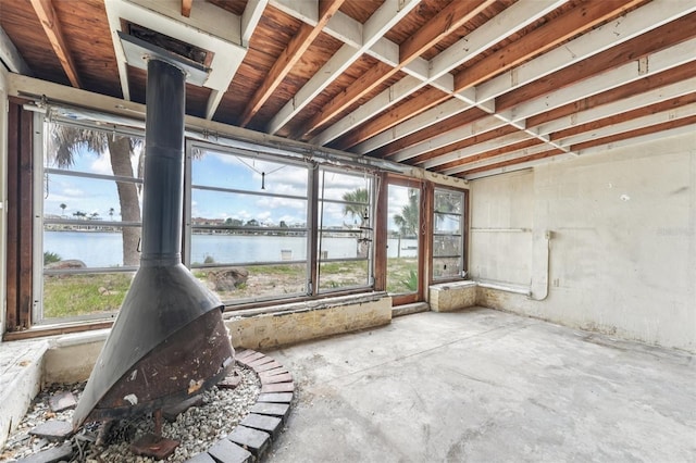 9300 Gulf Blvd, St Pete Beach, FL 33706 - unfurnished sunroom featuring a water view, a wood stove, and plenty of natural light