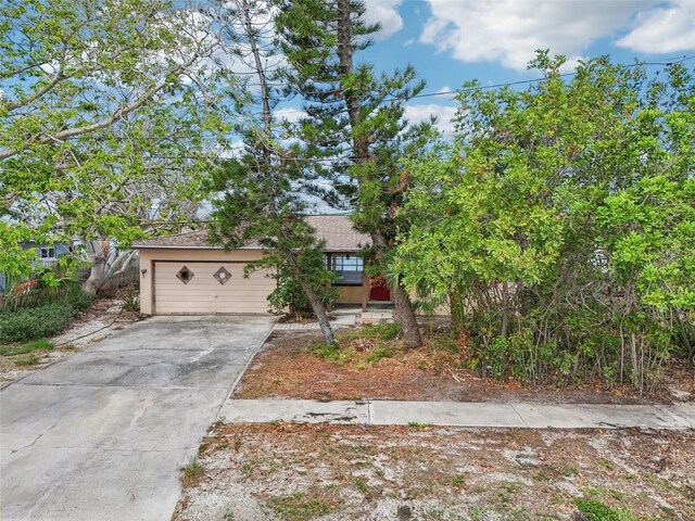 9300 Gulf Blvd, St Pete Beach, FL 33706 - view of property hidden behind natural elements featuring concrete driveway and stucco siding