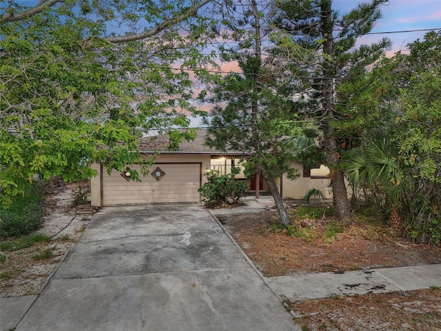 9300 Gulf Blvd, St Pete Beach, FL 33706 - obstructed view of property featuring driveway and stucco siding