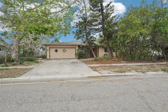 9300 Gulf Blvd, St Pete Beach, FL 33706 - view of front of property with concrete driveway, stucco siding, and a garage