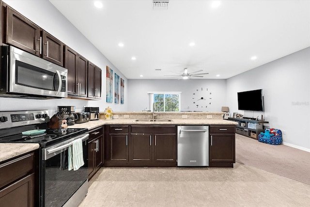 4644 Vignette Way, Sarasota, FL 34240 - kitchen with stainless steel appliances, a ceiling fan, dark brown cabinets, a peninsula, and light colored carpet