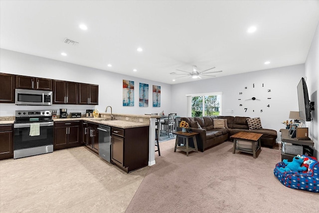 4644 Vignette Way, Sarasota, FL 34240 - kitchen with appliances with stainless steel finishes, dark brown cabinets, recessed lighting, a peninsula, and open floor plan